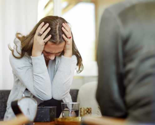 An LGBTQ identified lady struggling from a past trauma during a counselling session in a detox facility