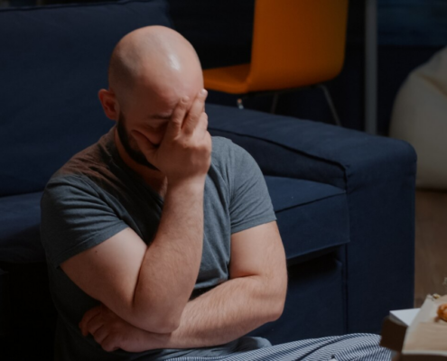An image of a distressed gay man, showing a symptom of PTSD.