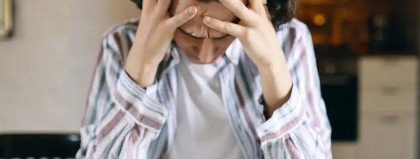Queer person with a distressed expression, conveying feelings of anxiety, trauma, and rejection.