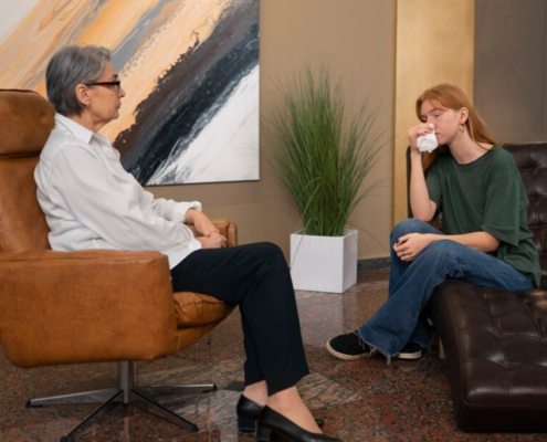A young trangender woman in an emotional therapy session with a counselor, representing the supportive environment of an intensive outpatient treatment program.