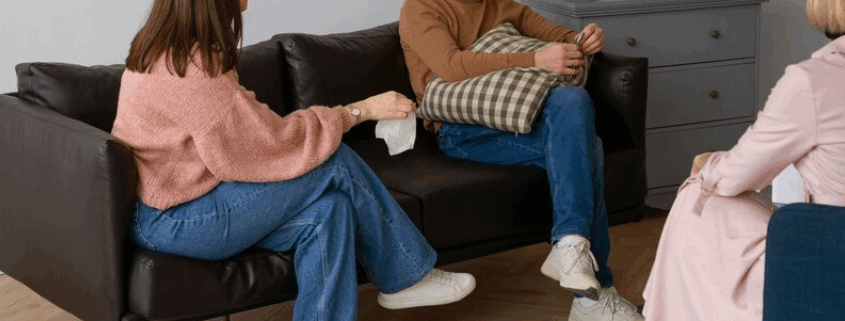 A gay person and two therapists in a trauma therapy session.