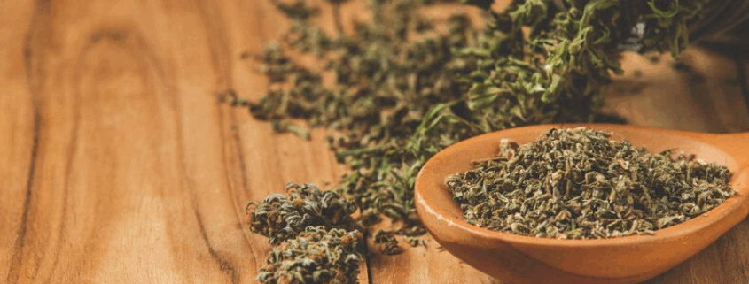 Loose synthetic cannabis (Spice) in a spoon and scattered on a table, representing the dangers of synthetic drug use.