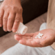 An image of a person's hand pouring white desoxyn tablets into his palm from a medicine container.