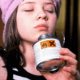 A young queer woman huffing glue through their nose
